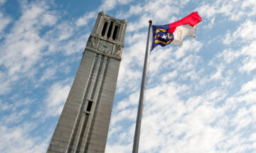 NC State's Memorial Belltower and North Carolina state flag