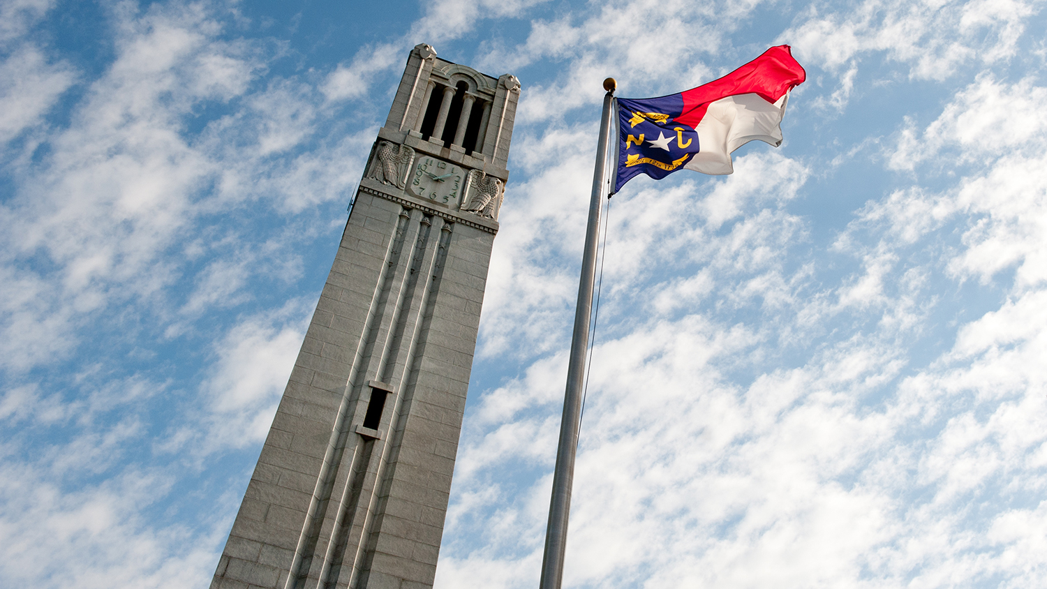 NC State's Memorial Belltower and North Carolina state flag