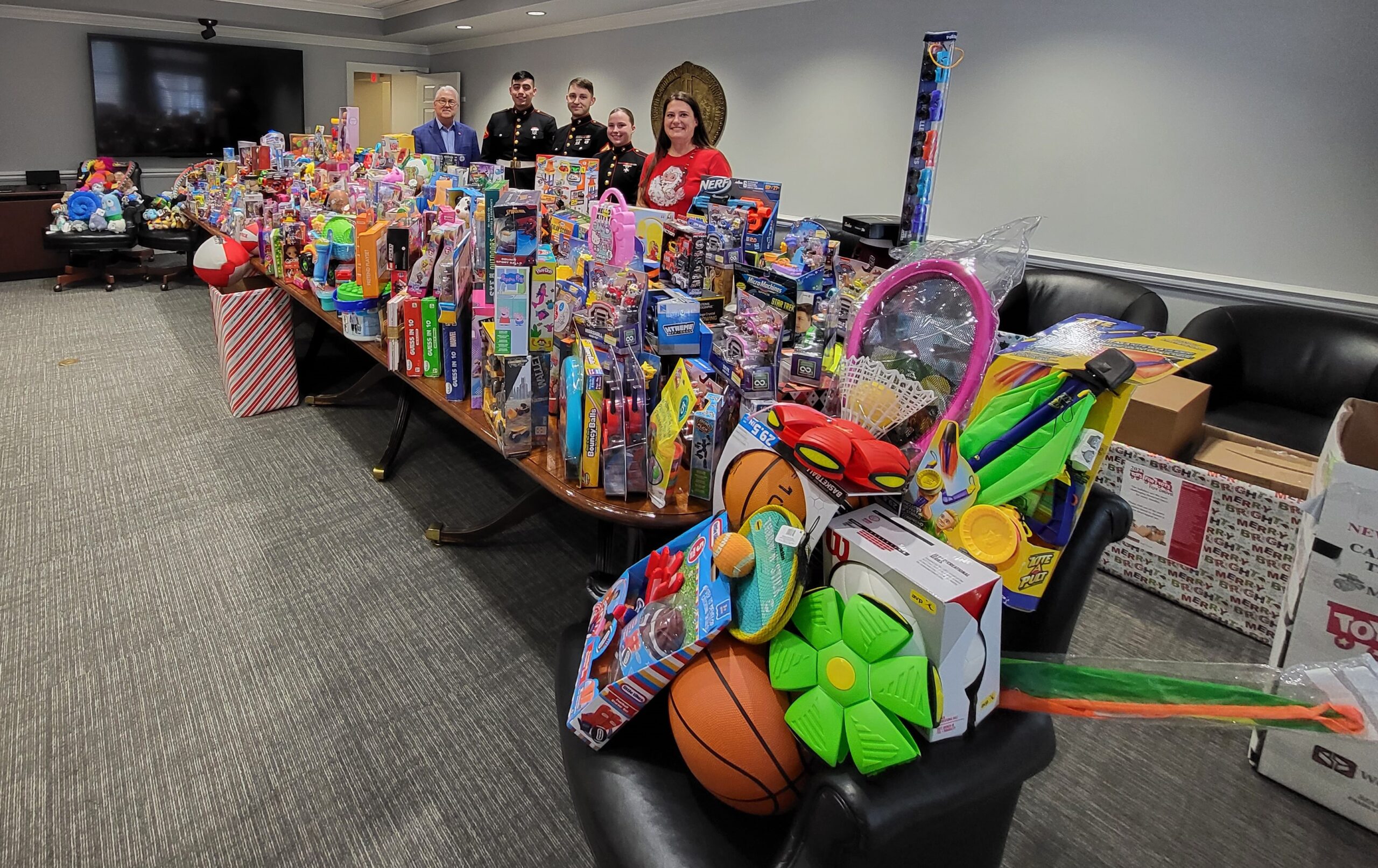 Representatives from Staff Senate, the US Military and Chancellor Woodson pose with toys collected during the 2023 toy drive